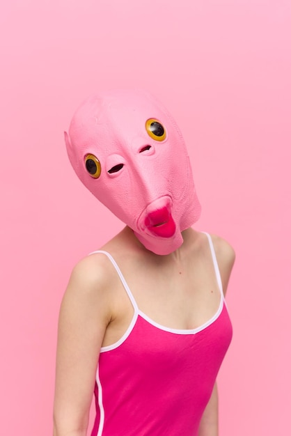 Modern halloween costume in a silicone mask in the shape of a pink fish head in a sexy costume the concept of a crazy look high quality photo