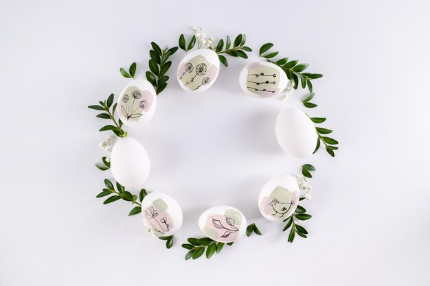 Photo modern hand painted easter egg on white background in the shape of a wreath happy easter poster and banner for greeting text top view