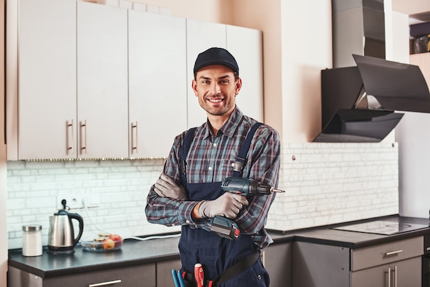 Photo modern handyman portrait of a smiling male foreman standing with perforator