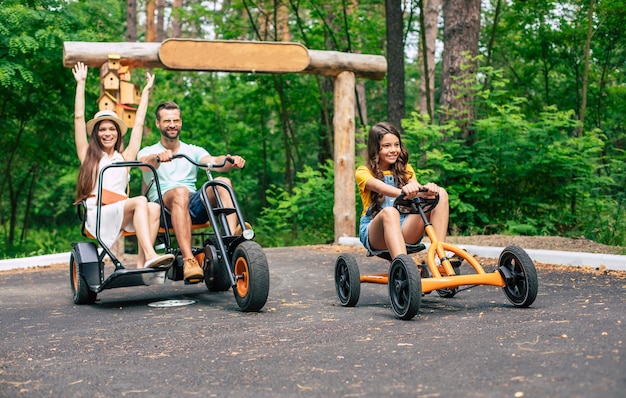 Modern happy young tourist family on vacation riding on bikes and have fun together