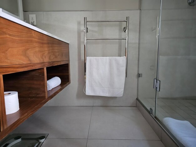 Photo modern heated towel rail on tiled in hotel