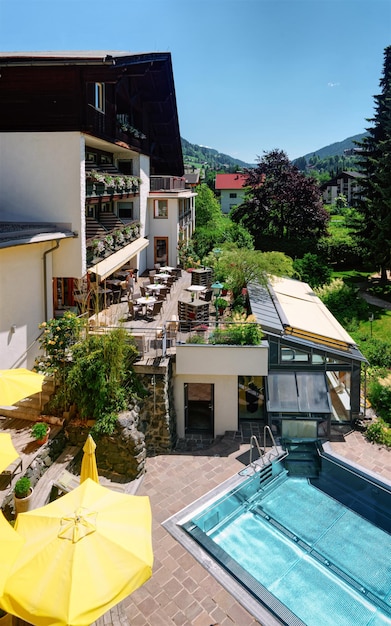 Modern hotel met zwembad met gele parasols op blauwe achtergrond. Zwembad om te ontspannen. Zomerplezier en bouwarchitectuur. Vakantie en vakantie op villa tijdens reis of vrije tijd.