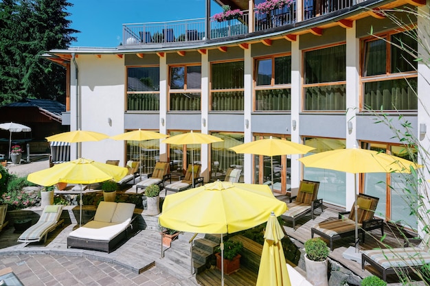 Foto modern hotel met zwembad met gele parasols op blauwe achtergrond. zwembad om te ontspannen. zomerplezier en bouwarchitectuur. vakantie en vakantie op villa tijdens reis of vrije tijd.