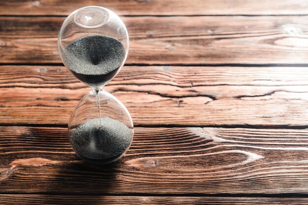 Modern hourglass on wooden surface