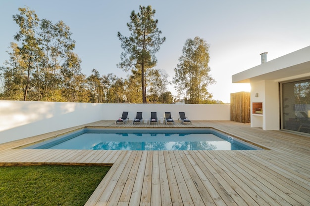 Modern house with garden swimming pool and wooden deck