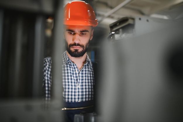 Modern industrial machine operator working in factory