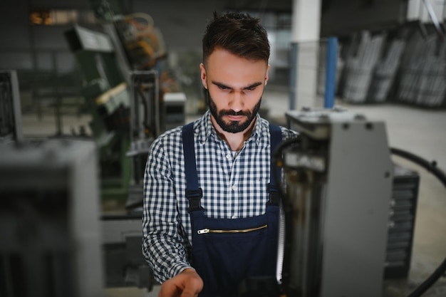 Foto moderno operatore macchina industriale che lavora in fabbrica