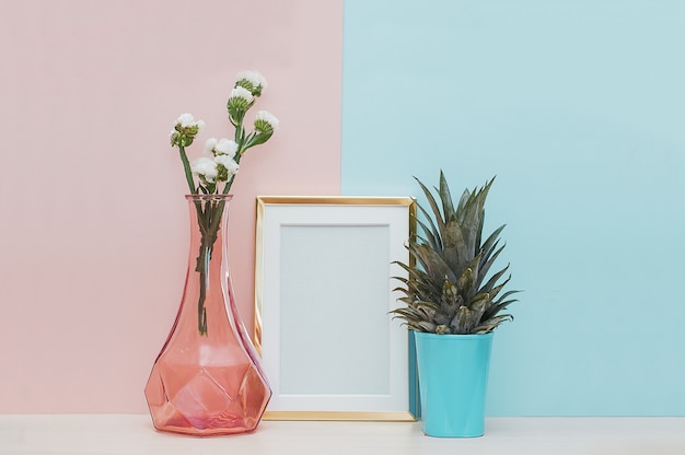 Modern interieur mock-up met gouden fotolijst, vaas en tropische plant op roze blauwe rug