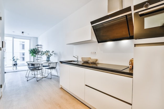 Modern interior design of small home kitchen of unusual geometric shape with furniture and appliances in white and black tones