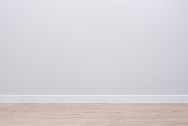 Modern interior of an empty apartment, gray walls, wooden\
floor.