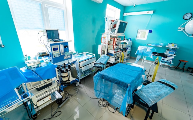 Modern interior hospital room. Ultra new and present equipment for surgery. Interior of operating room in modern clinic. Lamps and ultra modern devices.