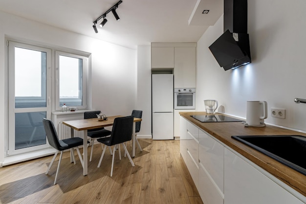 Modern interior of kitchen wooden furnitureand stylish table and chairs Spacious and luxurious space in apartment