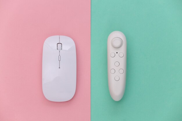 Modern joystick and pc mouse on a blue-pink pastel background.\
top view. gadgets and devices. flat lay