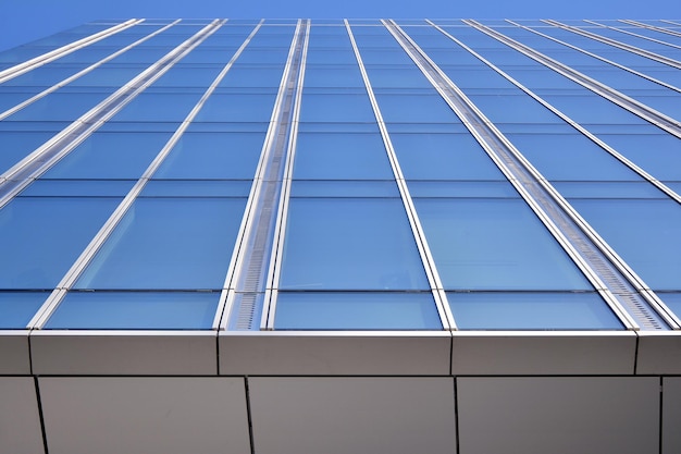 Modern kantoorgebouw met glazen gevel op een heldere hemelachtergrond Transparant glas