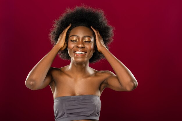 Modern kapsel. Gelukkig positieve vrouw die haar ogen sluit terwijl ze haar haar aanraakt