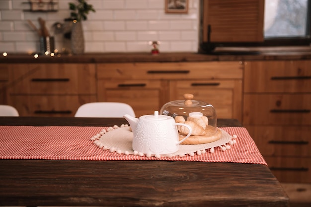 Modern kitchen countertop at loft interior. Tea and croissants on a wooden table.