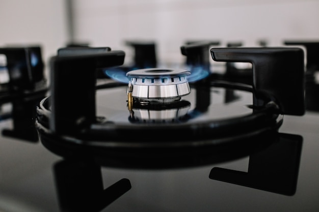 Foto cucina moderna stufa cucina con fiamme blu che brucia.