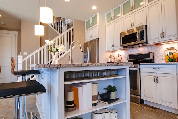 Modern kitchen with white cabinets and stainless appliances.