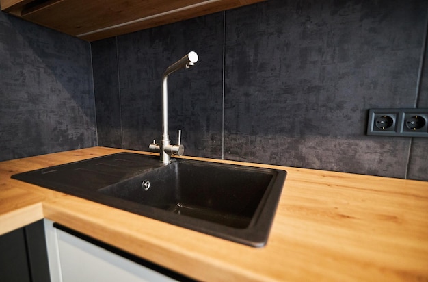 Modern kitchen wood worktop and backsplash black kitchen sink\
and black water faucet