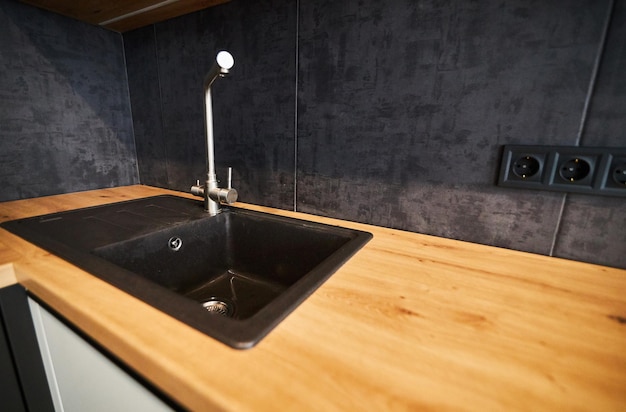 Modern kitchen wood worktop and backsplash black kitchen sink
and black water faucet