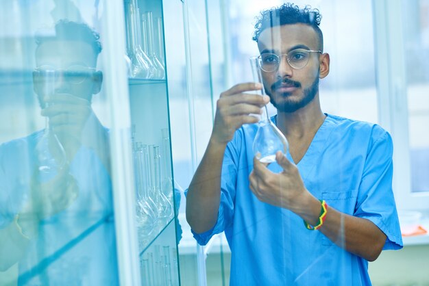 Modern lab technician working with glassware