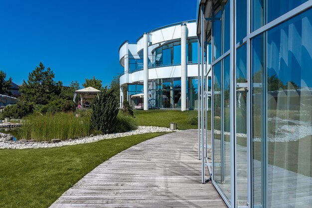 Modern landhuis en aangelegde groene tuin met terras op zonnige zomerdag