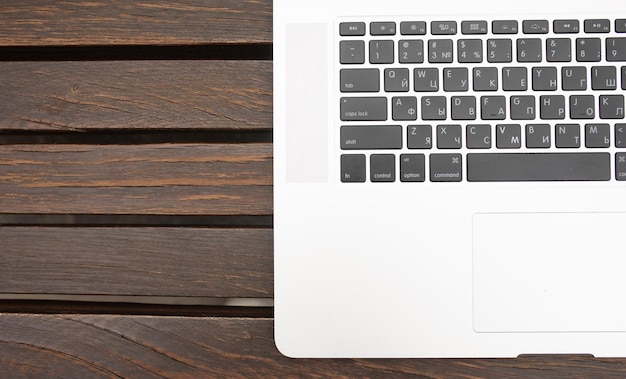 Modern laptop computer on brown wooden background