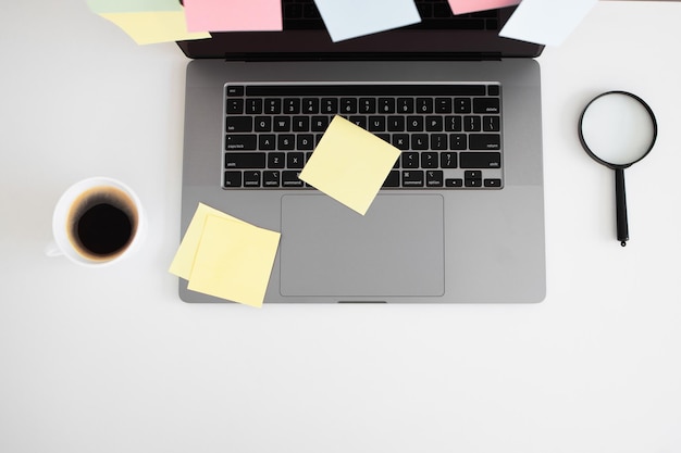 Modern laptop cup of coffee on table and sticky notes