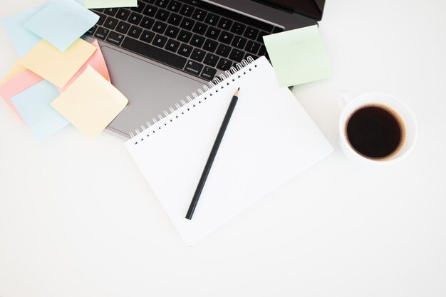 Modern laptop and different sticky notes on white wall