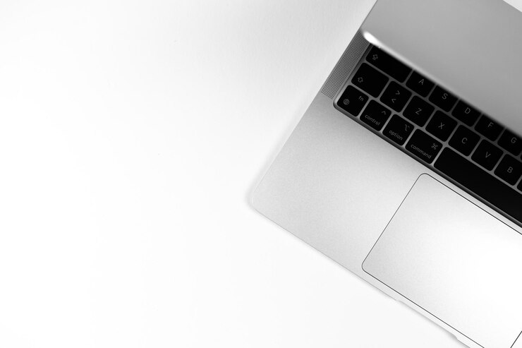 現代のラップトップフラットは銀色の背景を置きました。ノートブックキーボード。オフィスの職場のテーブル、最小限のデザインコンセプト。上面図、コピースペースの写真