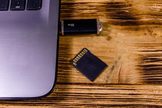 Фото Современный ноутбук, sd и карта флэш-памяти на деревянном столе