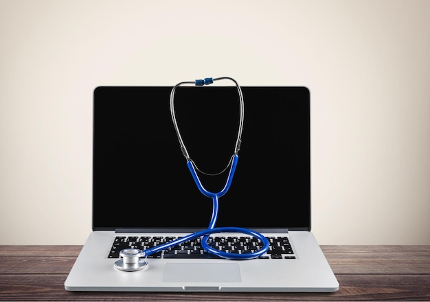 Modern laptop and stethoscope isolated on  background