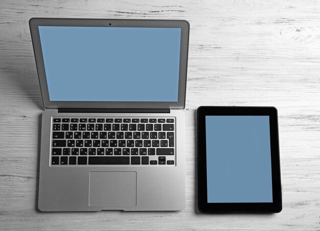 Modern laptop and tablet on white wooden background