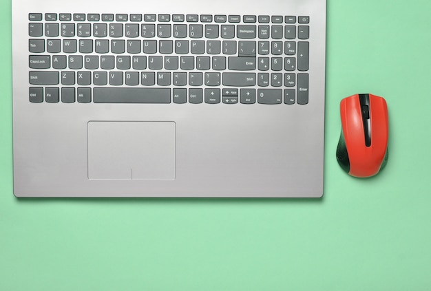 Modern laptop, wireless mouse on a blue pastel background