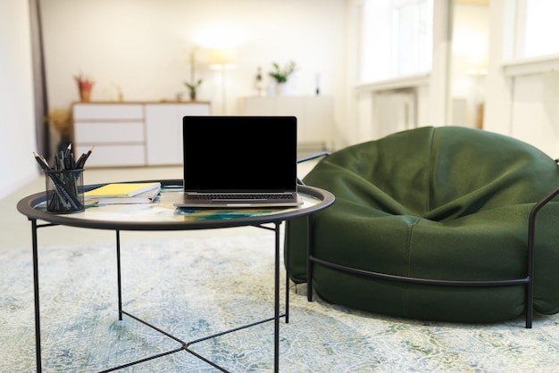 Modern laptop with black empty screen on table mockup