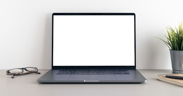 미니멀한 책상에 빈 흰색 화면이 있는 현대적인 노트북 모의 템플릿