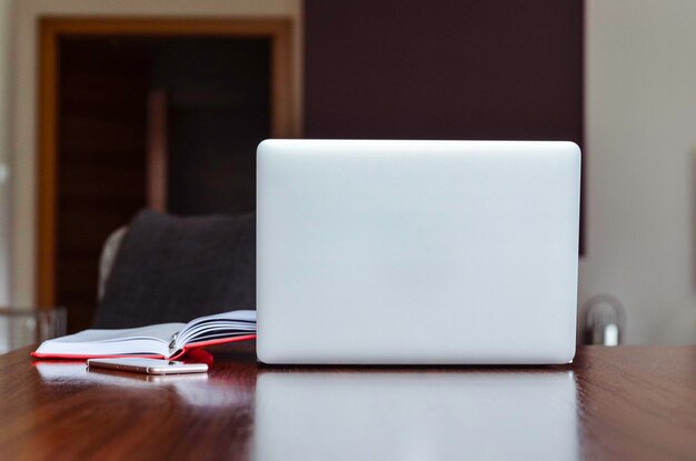 Photo modern laptop on wooden table in the room