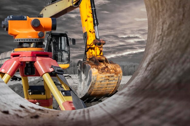 Photo modern level for geodesy at a construction site surveyors ensure precise measurements before undertaking large construction projects excavator on the background of the sunset sky contrast image