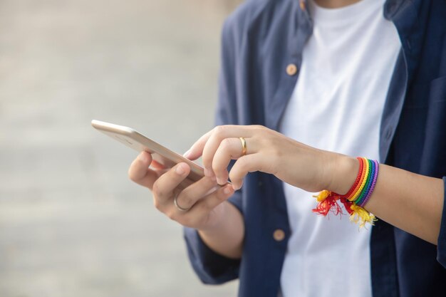 Modern LGBT woman with ribbon symbol using smartphone concept of LGBT or LGBTQ people community friends partner lgbt rights campaign equality same sex marriage sex preference diversity