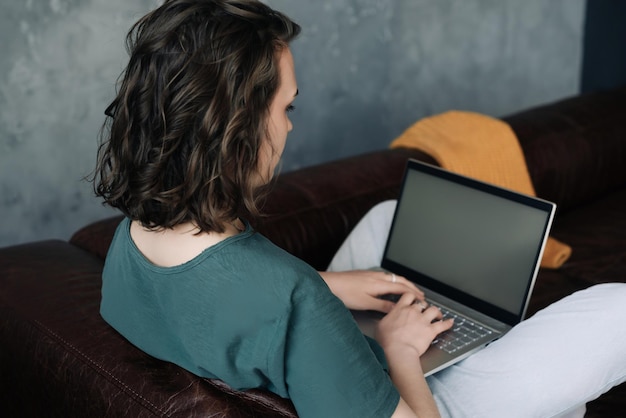 Stile di vita moderno giovane donna che lavora da casa con il computer portatile che mostra il mockup di schermo vuoto illust