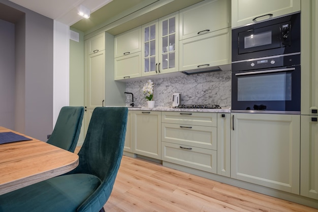 식탁이 있는 현대적인 밝은 녹색의 고급스러운 주방