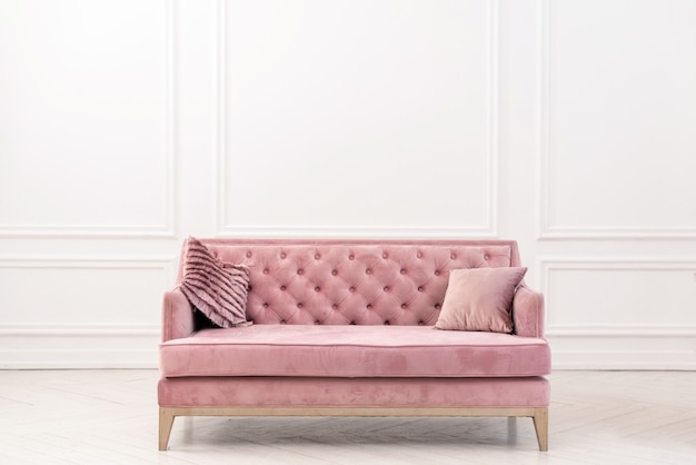 Modern living-room minimalist  interior with pink sofa near empty white wall.