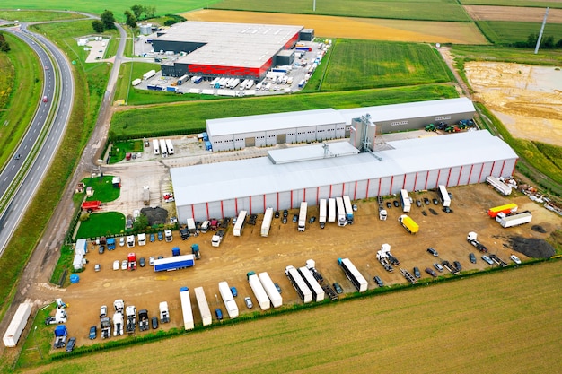 Modern logistics center and many trucks awaiting unloading. Warehouses of mail and online stores