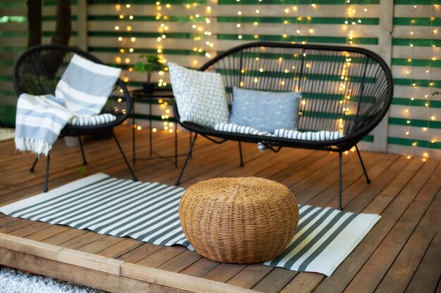 Foto moderna lounge patio terrazza casa con pavimento in legno comodo divano poltrona e pouf in vimini