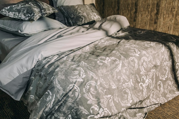 Modern luxueus zacht bed met grijze tinten en creatief patroon ochtendzonnestraal in slaapkamer
