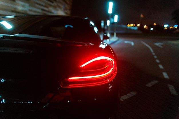 Automobile nera di lusso moderna con la luce di arresto di notte