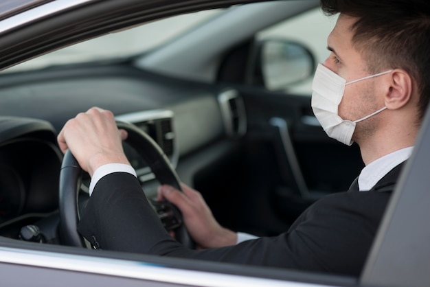 Modern man in car with mask