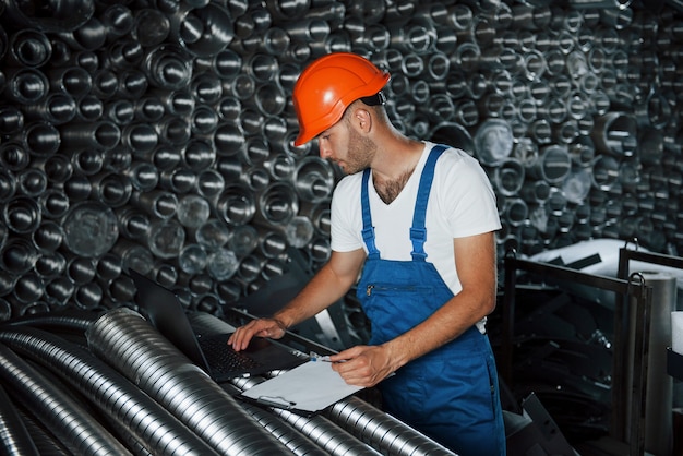 Produzione moderna. l'uomo in uniforme lavora alla produzione. tecnologia moderna industriale.