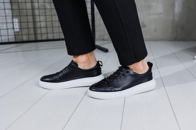 Modern men's shoes male legs in black pants and black casual
sneakers men's fashionable shoes