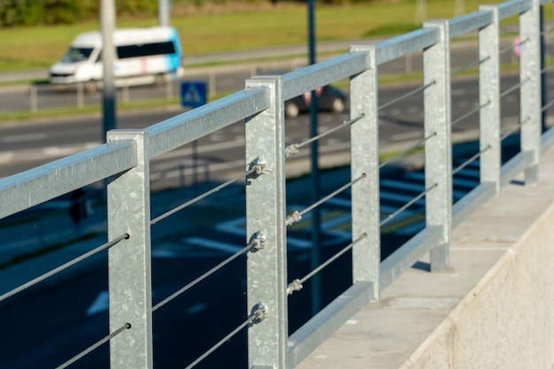 Modern metal fence made of metal profiles and cables Connection and fastening of iron cables with a steel turnbuckles Metal fastening of two steel rope Fencing around the perimeter of the roof